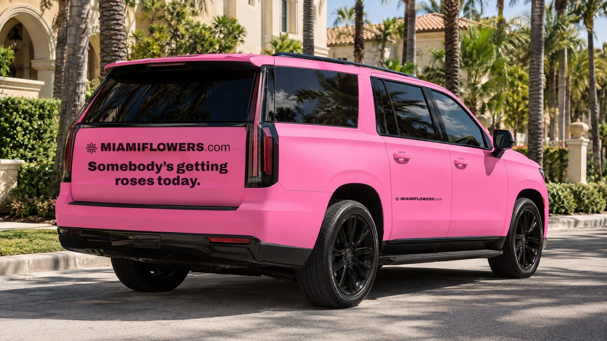 Rear of a pink MIAMIFLOWERS.com Escalade reading 'Somebody's getting roses.'