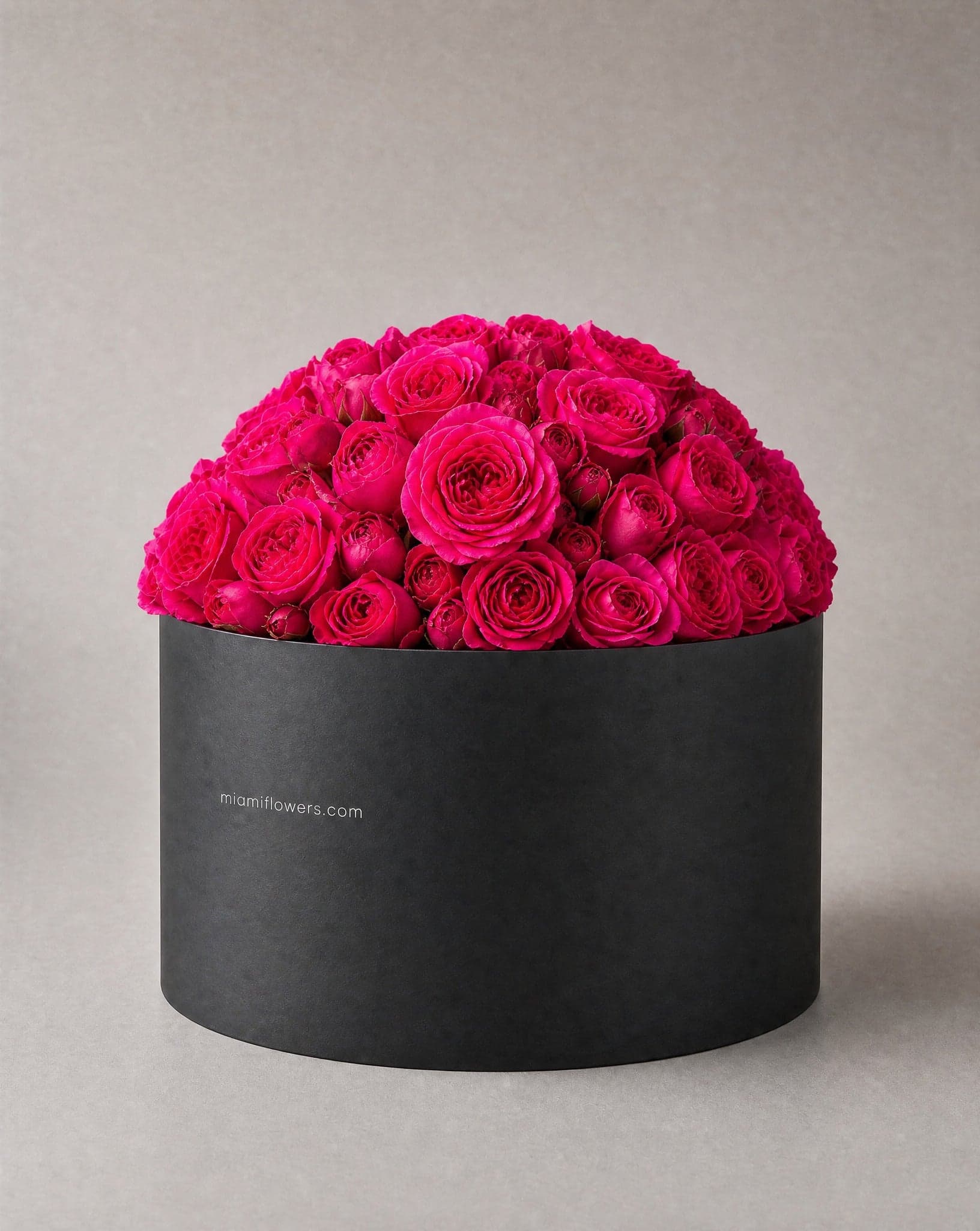 Hot pink and fuchsia roses in a tall matte black oval box printed with miamiflowers.com